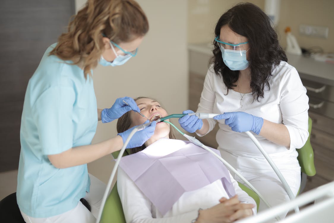 A Dentist Working On Her Patient's Teeth