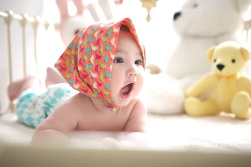 Free Toddler Wearing Head Scarf in Bed Stock Photo