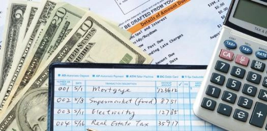 5 Personal Finance Hacks That Can Help You Break Out Of The Paycheck To Paycheck Cycle | My Zeo Budgeting worksheet with cash, bills, and a calculator.