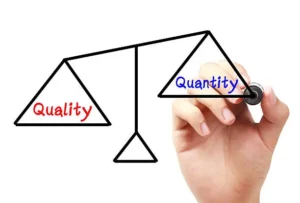 Balance scale with 'Quality' on the left and 'Quantity' on the right, drawn by a hand to symbolize balancing quality and quantity.